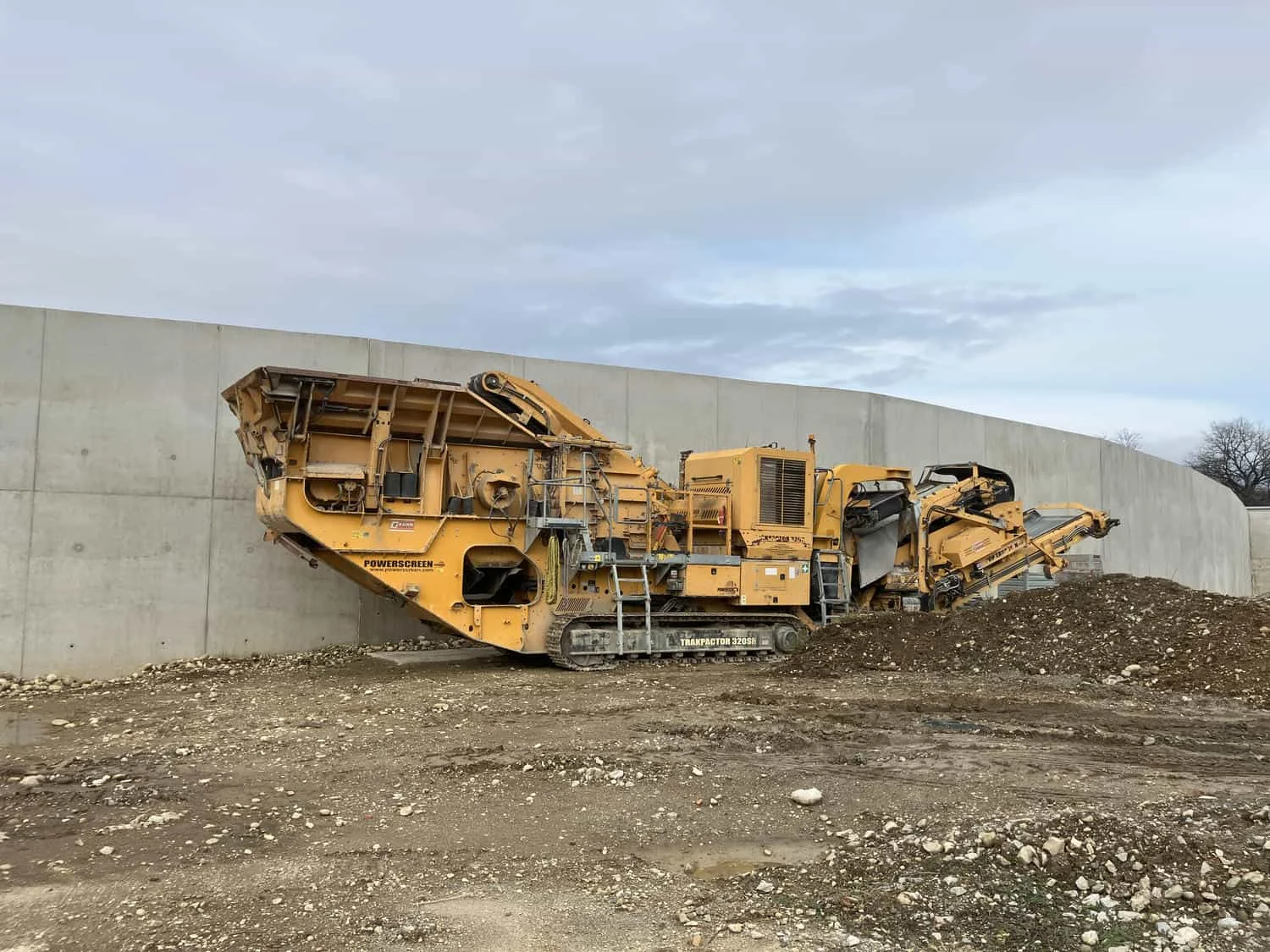 Mobile yellow impact crusher operating on construction site