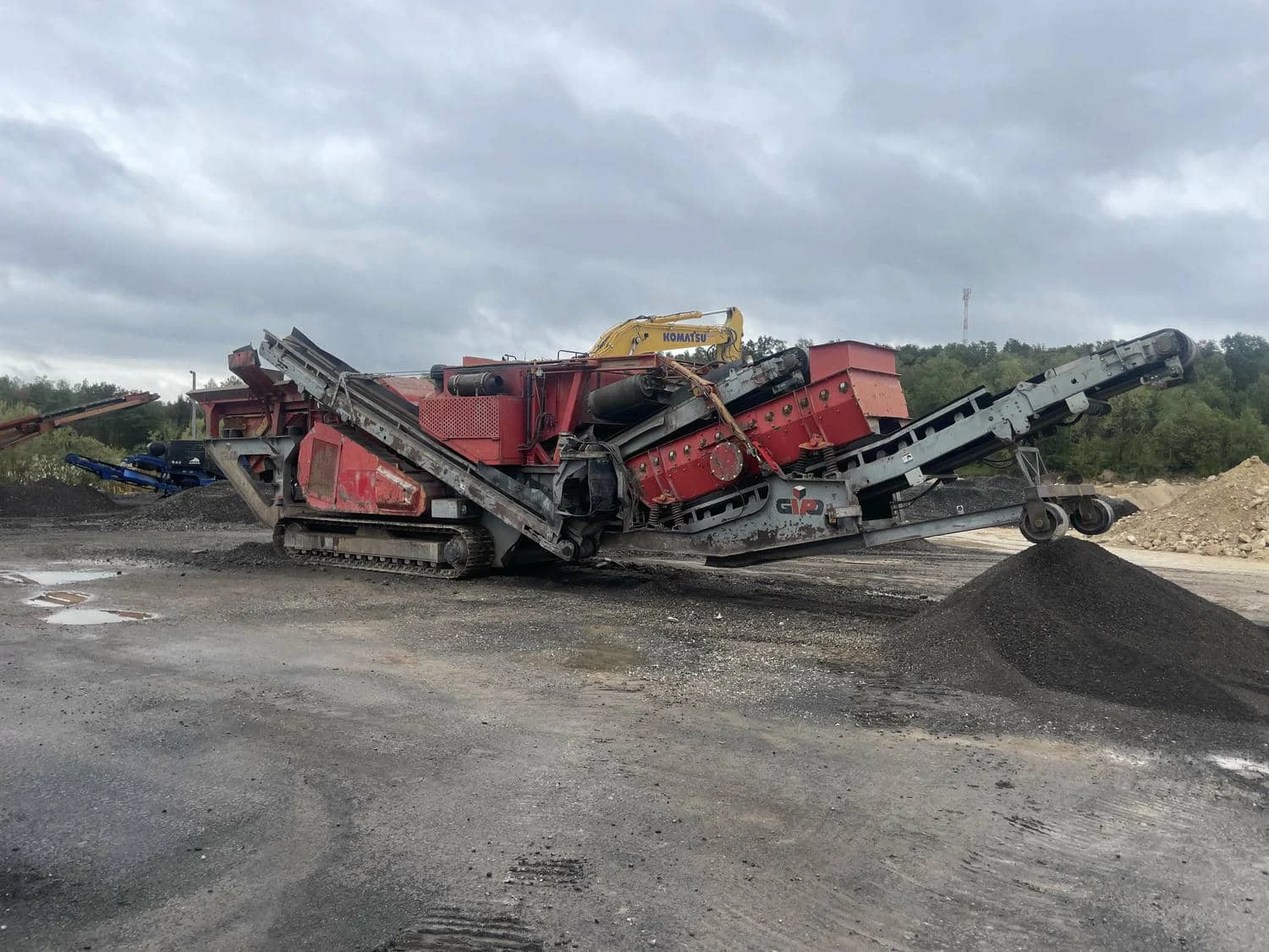 Mobile GIPO impact crusher in operation with discharge conveyor and stockpile